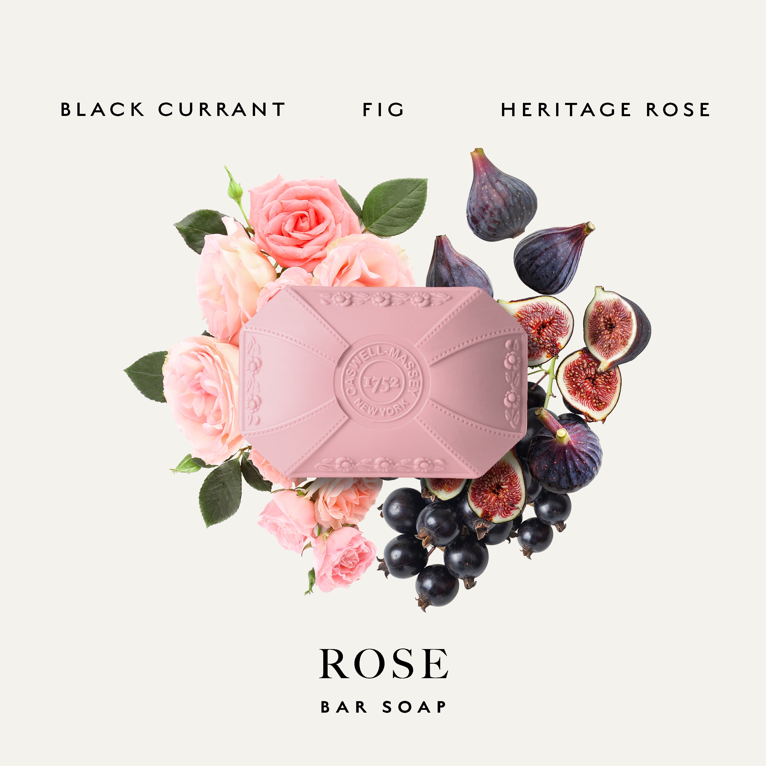 A pink bar soap, Caswell-Massey Rose Bar Soap, is centered on a light warm-gray background, surrounded by pink roses, figs, and black currants. Text at the top reads 'BLACK CURRANT FIG HERITAGE ROSE' and text at the bottom reads 'ROSE BAR SOAP'.