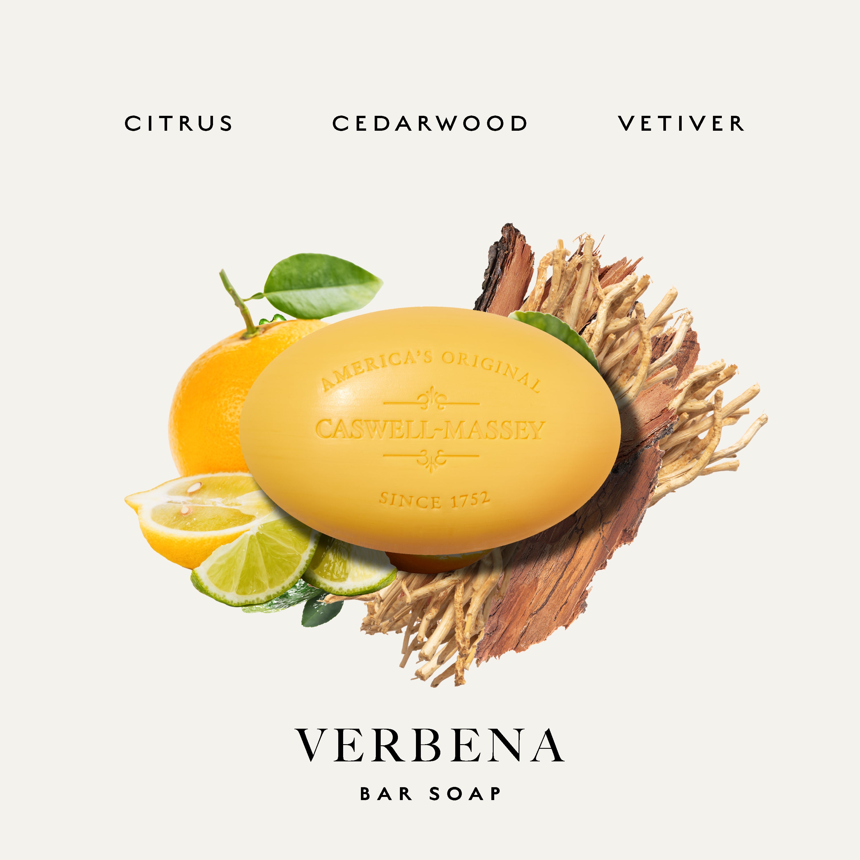 Castwell-Massey Verbena Bar Soap in a citrus and wood-slice presentation on a light cream background. The yellow bar of soap is embossed with 'America's Original Castwell-Massey of Cedarwood Since 1752'.