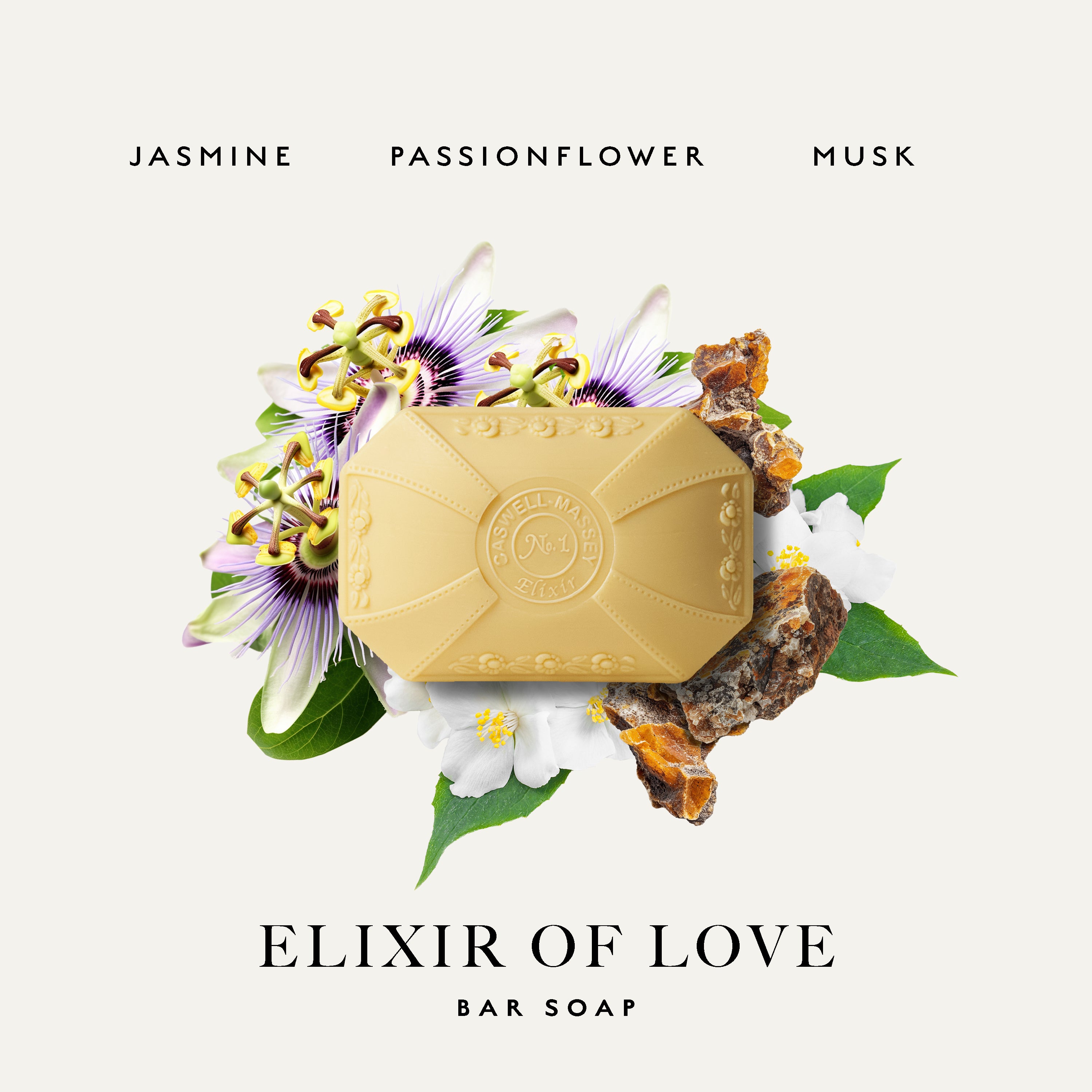 A bar of Caswell-Massey Elixir of Love bar soap in a pale golden-yellow color, styled with passionflower blossoms, green leaves, and amber pieces on a white background. Text at the top reads 'JASMINE PASSIONFLOWER MUSK' and text at the bottom reads 'ELIXIR OF LOVE BAR SOAP'.