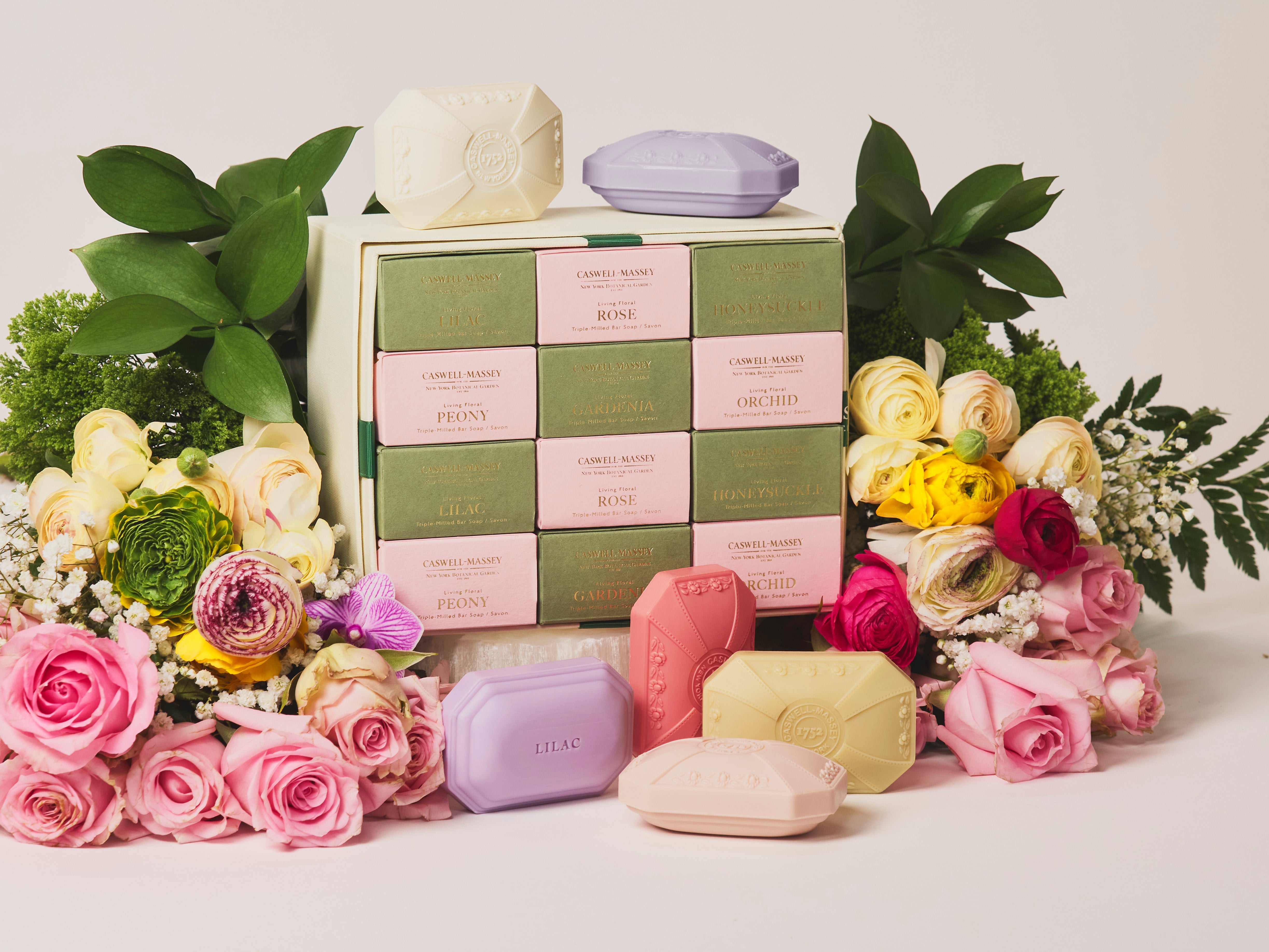 Caswell-Massey Designer Floral 12 Soap Gift Set shown surround by jewel-toned soaps and mixed floral bouquet