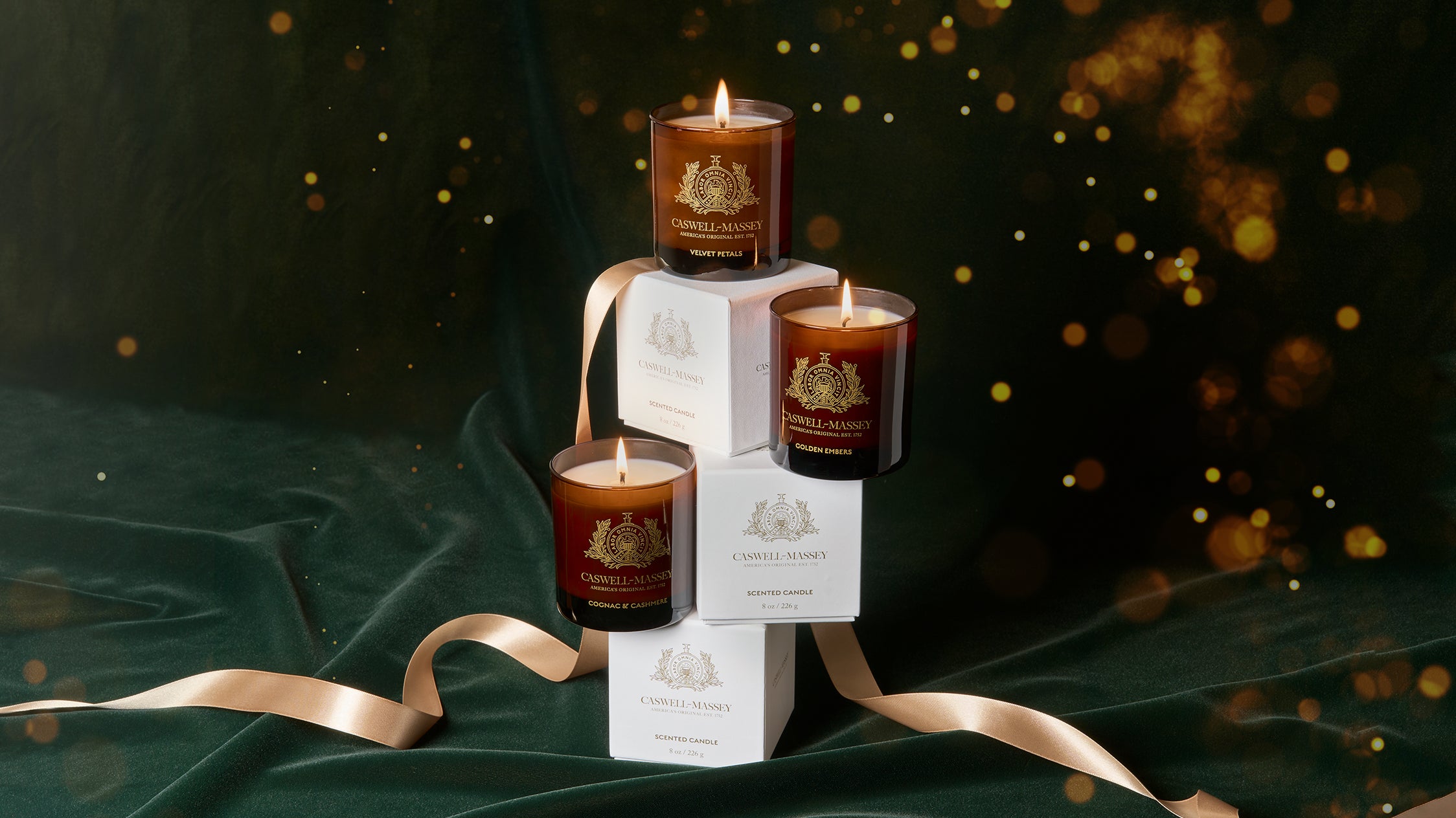 Caswell-Massey Home Fragrance Collection: Cognac & Cashmere Candle, Velvet Petals Candle, and Golden Embers Candle.