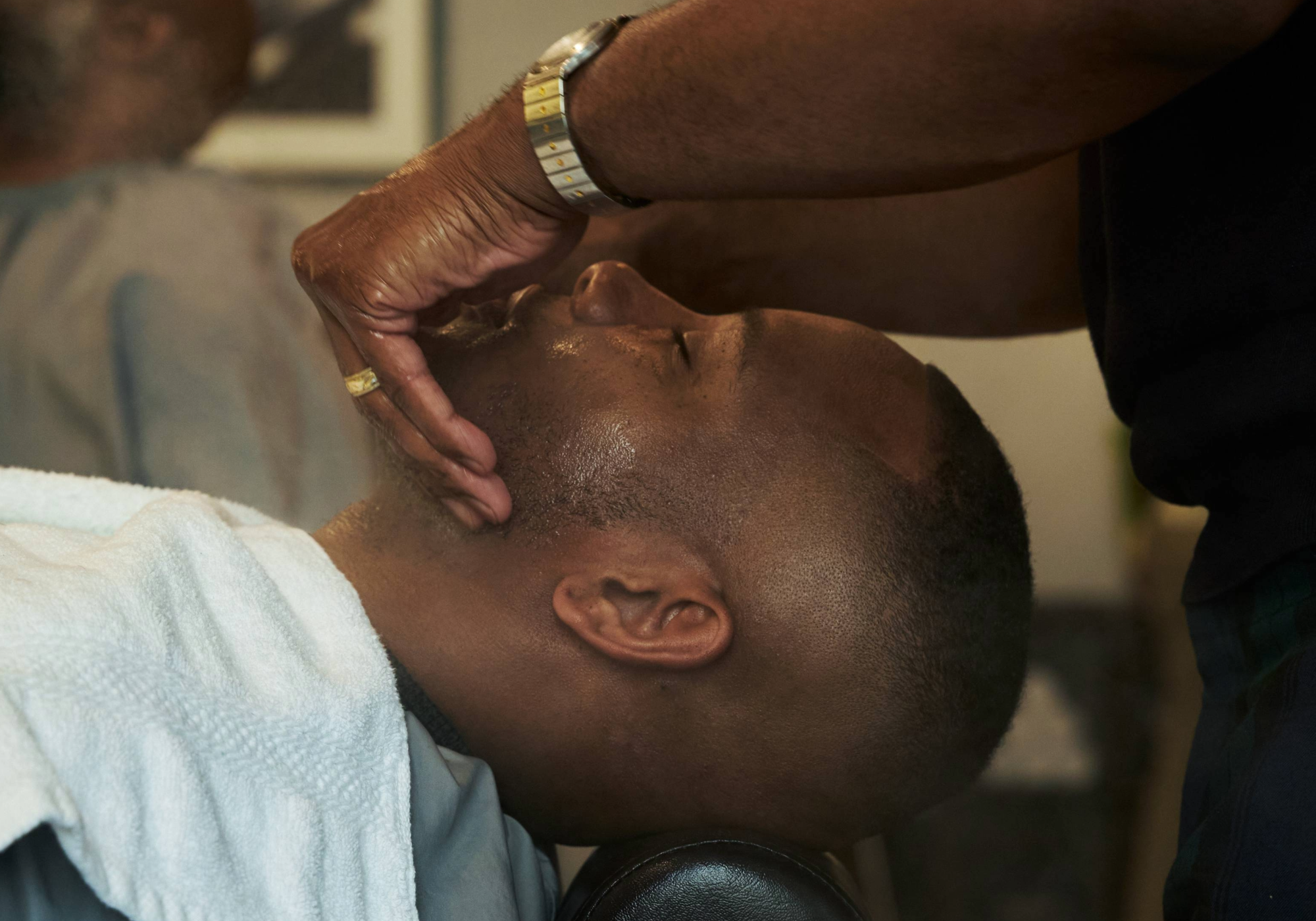 Caswell-Massey Pre-Shave Almond Oil: barber applying Almond Pre-Shave Oil to man's face prior to shaving