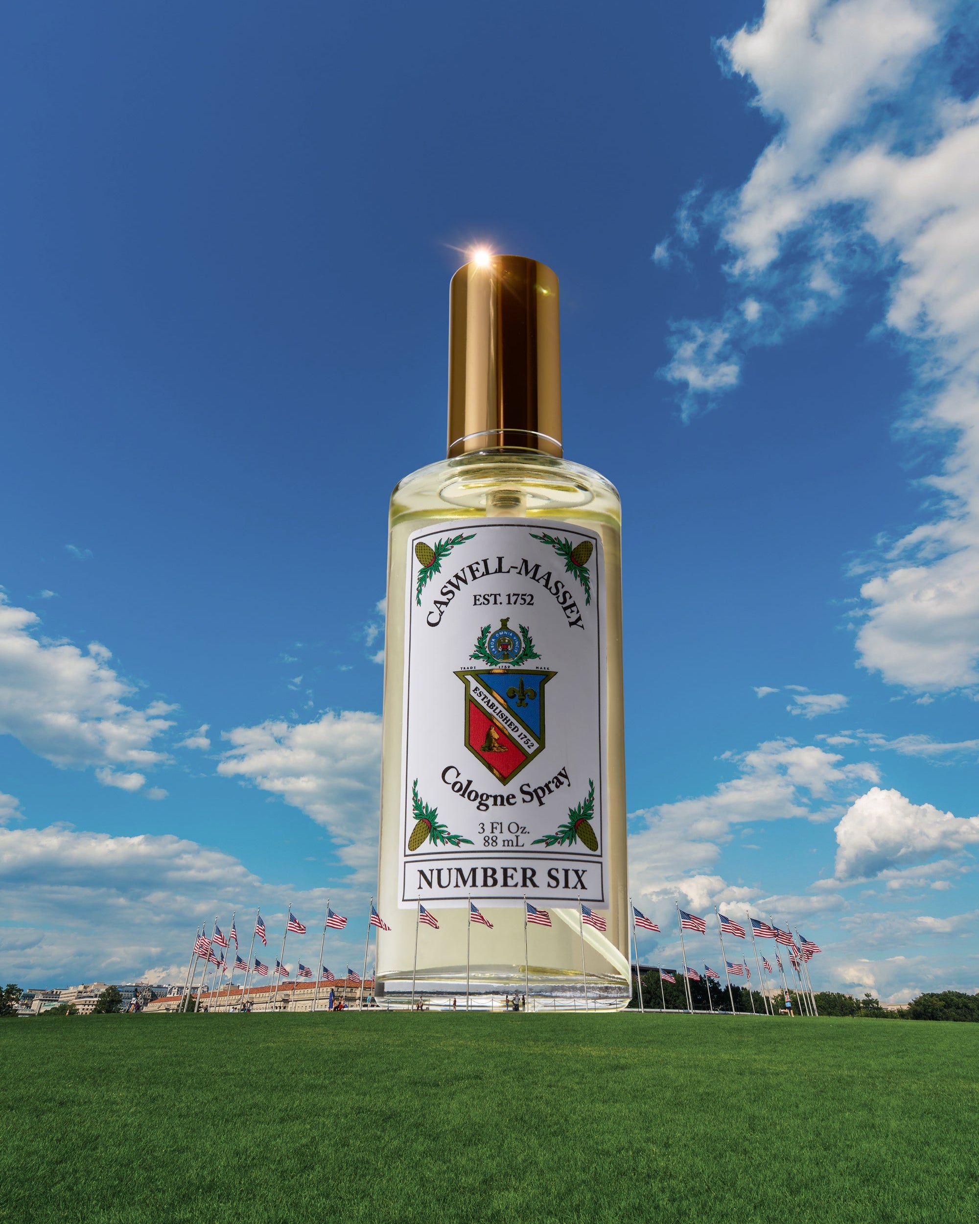 Caswell-Massey Number Six Cologne for men. Large model of a cologne bottle with a blue sky and clouds in the background