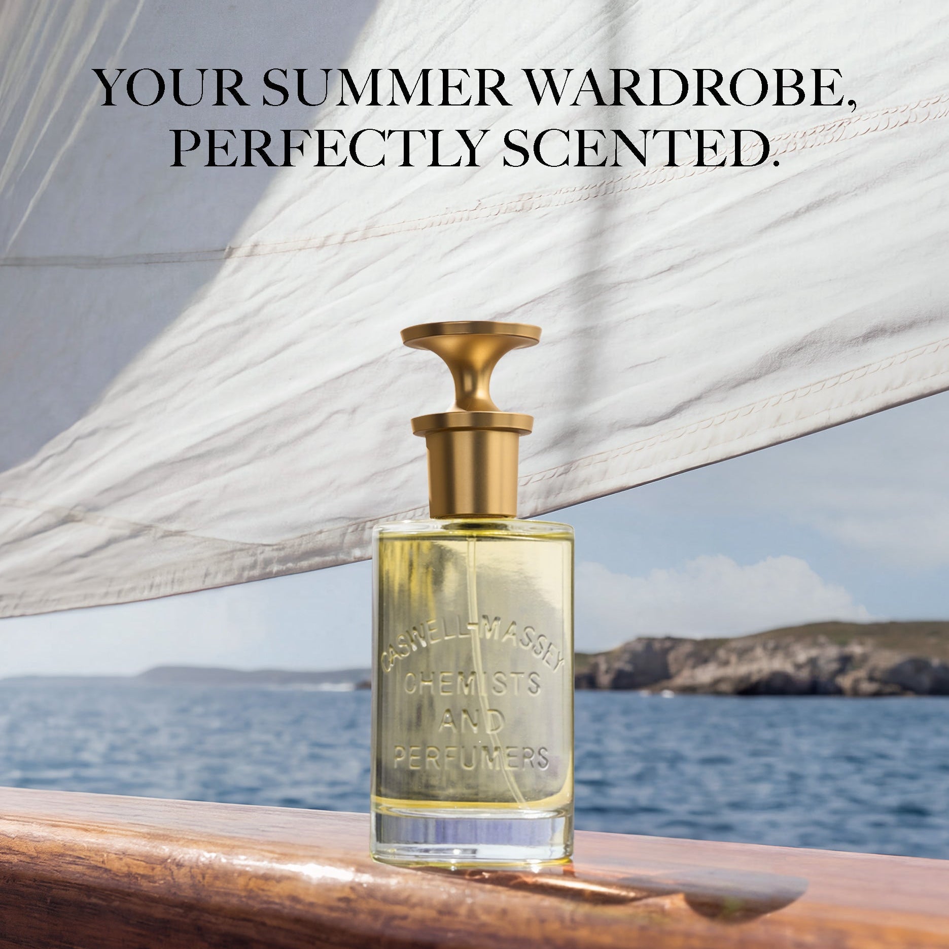 A perfume bottle with a gold cap stands on a wooden deck railing with the sea and distant cliffs in the background, under a white sail. Text at the top reads, 'YOUR SUMMER WARDROBE, PERFECTLY SCENTED.