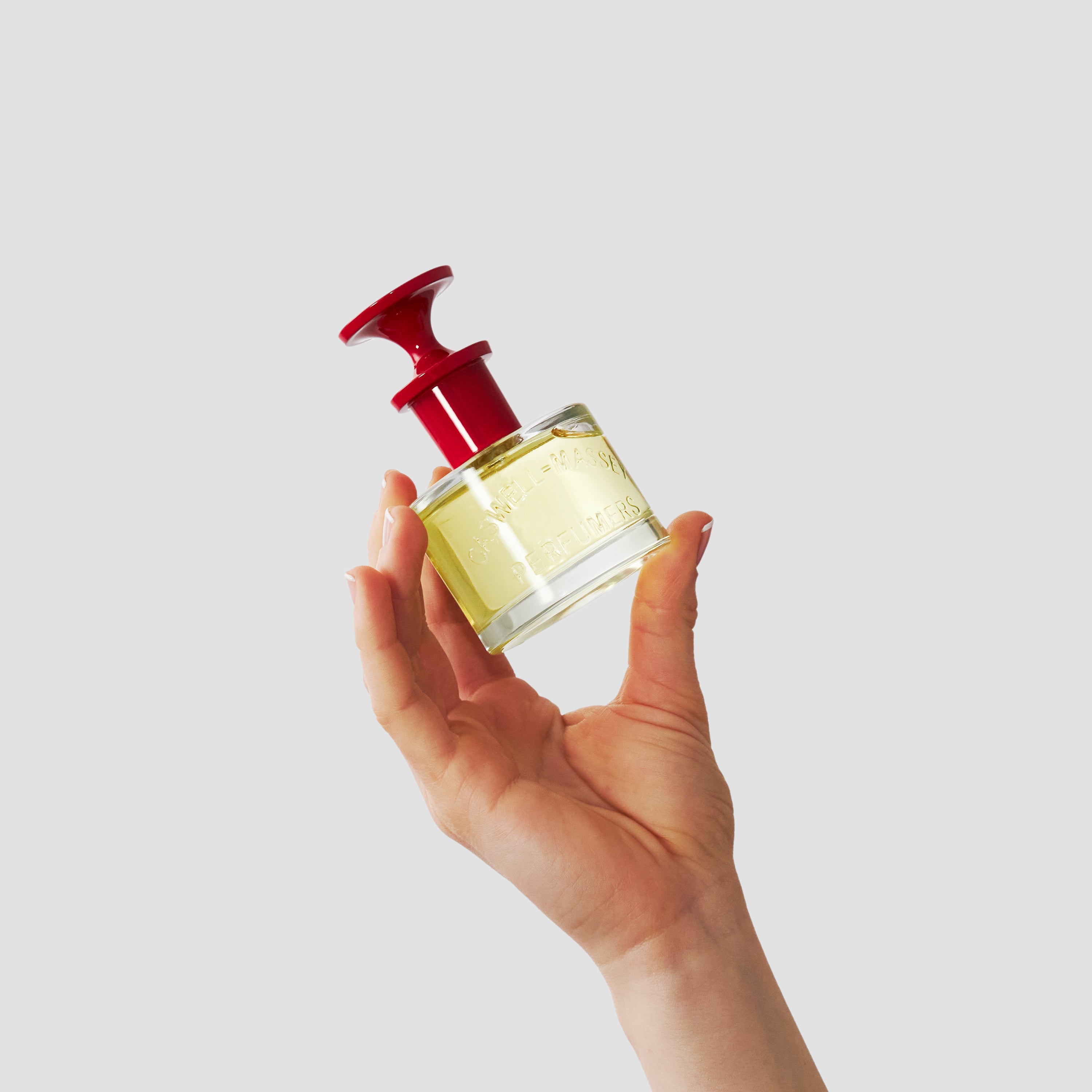 Caswell-Massey Fragrance for Women Collection: woman's hand holding up Marem Perfume (60 mL) with red cap