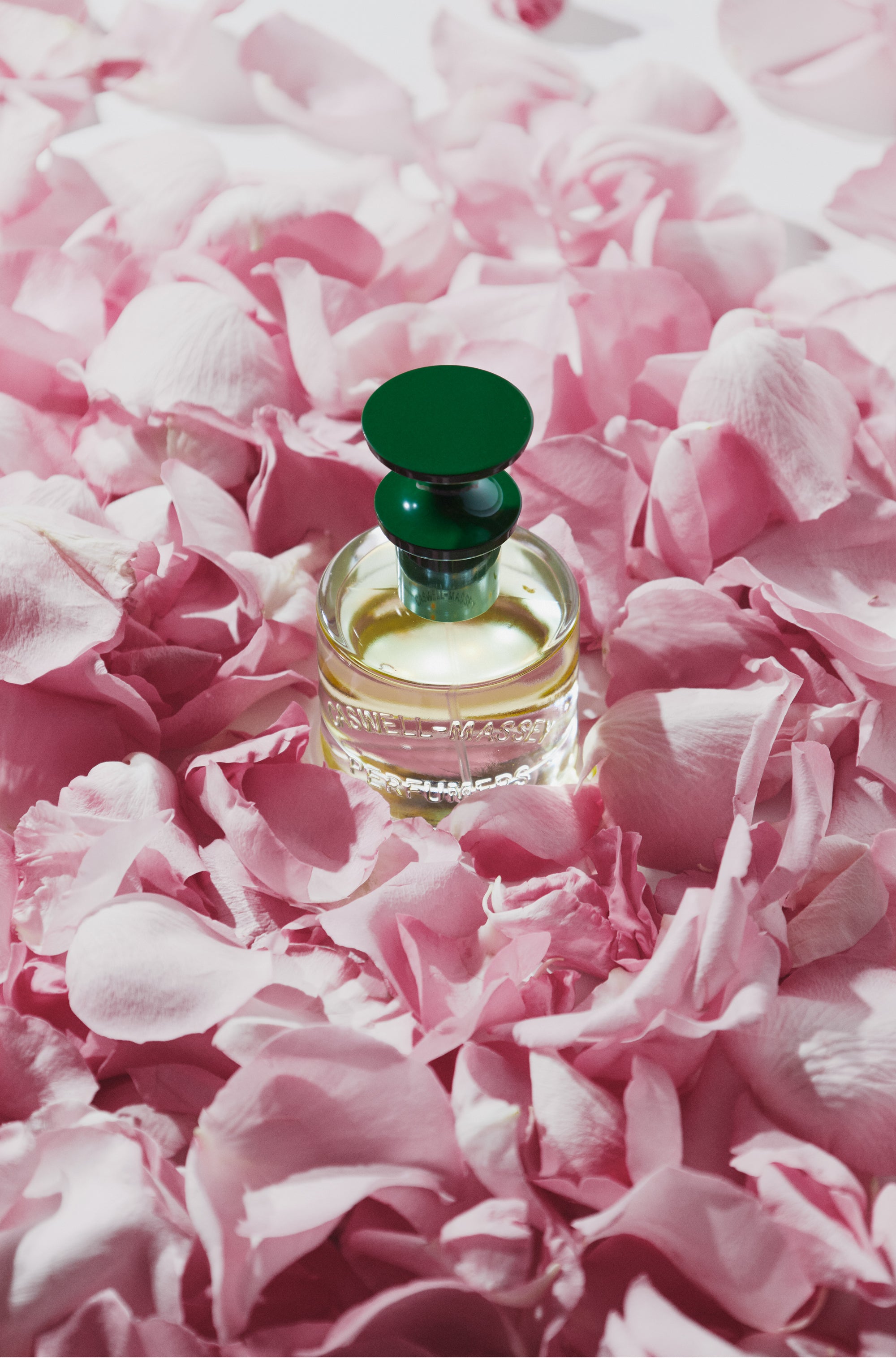 Rose Perfume by Caswell-Massey standing in a bed of soft pink rose petals 