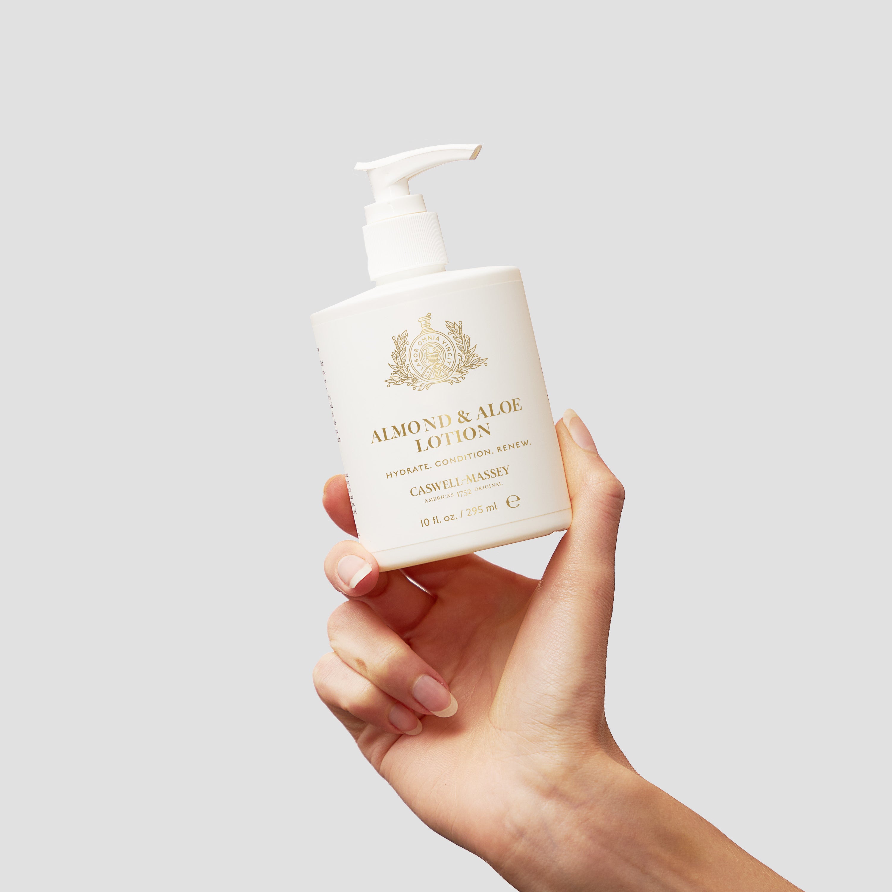 Caswell-Massey Almond Hand and Body Lotion 10 oz. held in hand