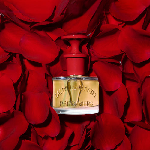 a bottle of perfume on a pile of red rose petals