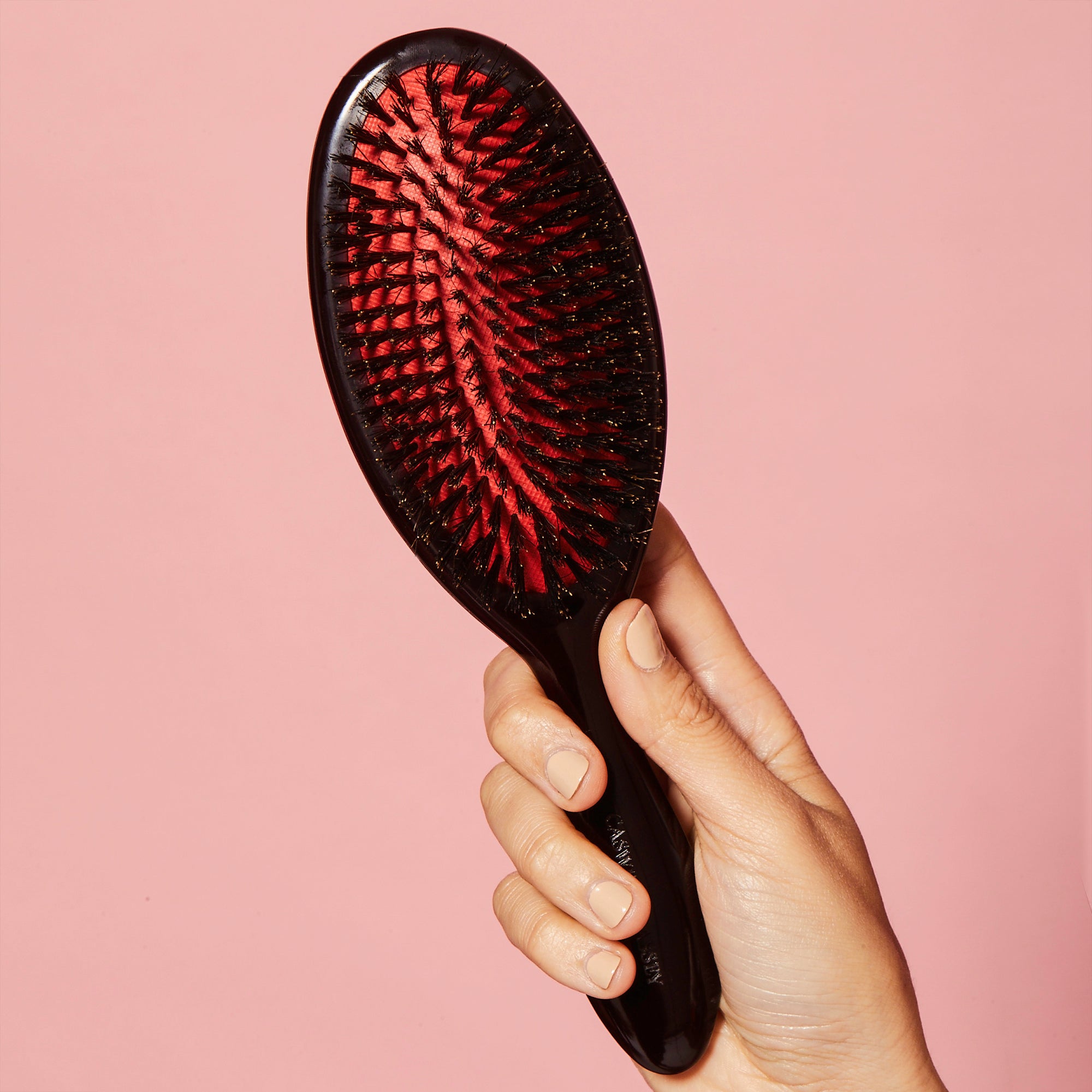 Caswell-Massey Standard Boar Bristle Hair Brush being held by woman's hand