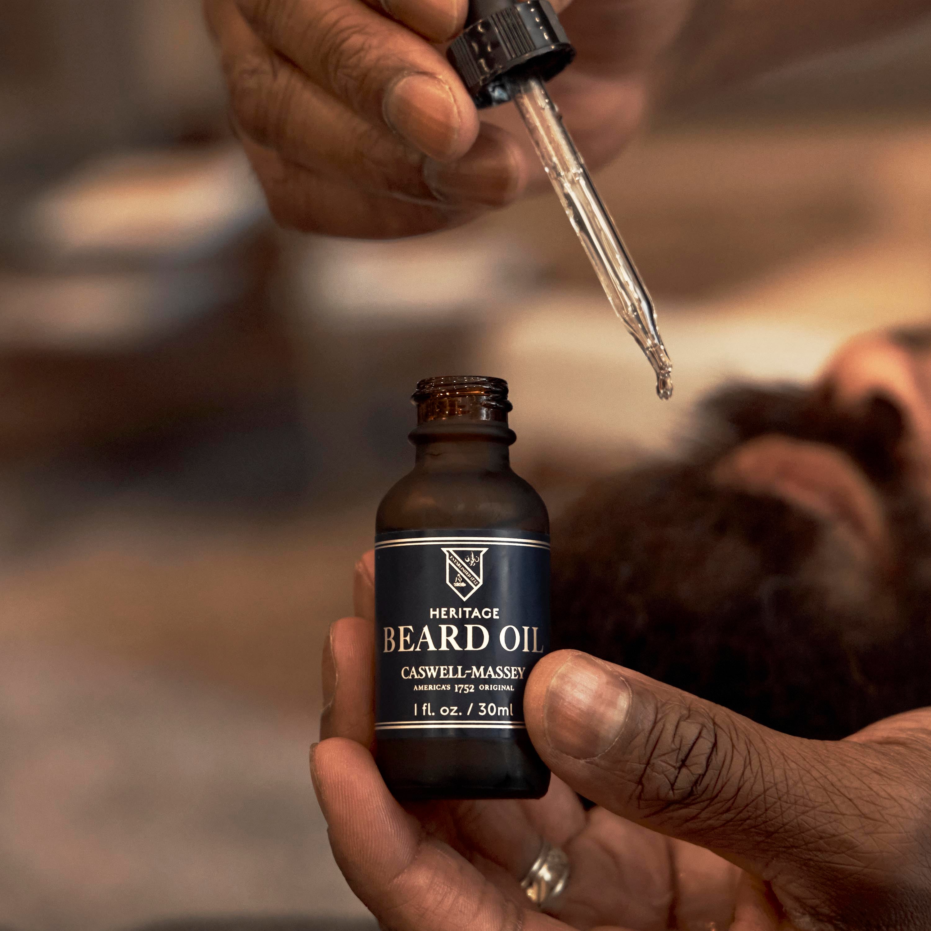 Caswell-Massey Face & Beard Oil - image showing barber applying to man's beard