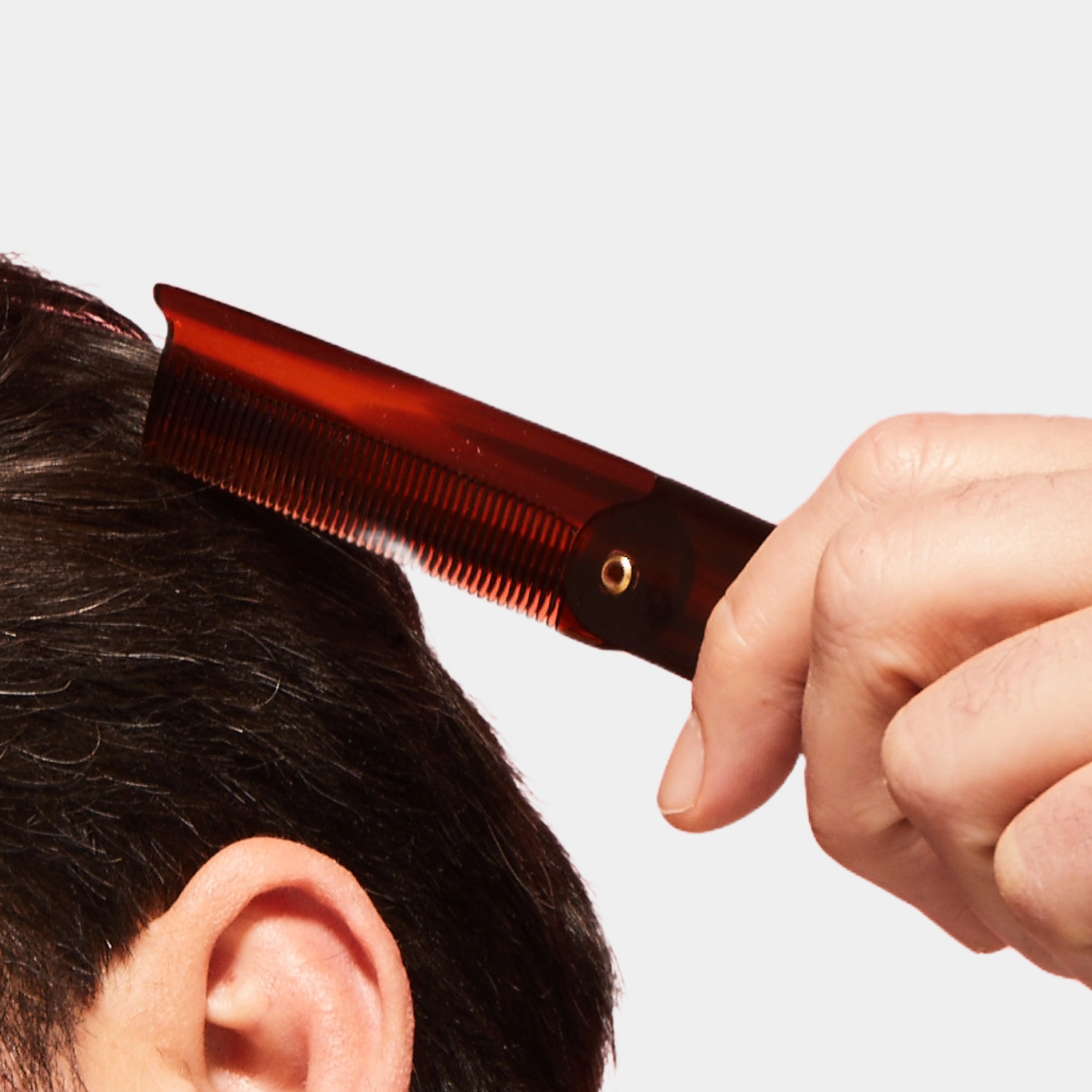 Caswell-Massey Folding Pocket Comb: man shown combing hair