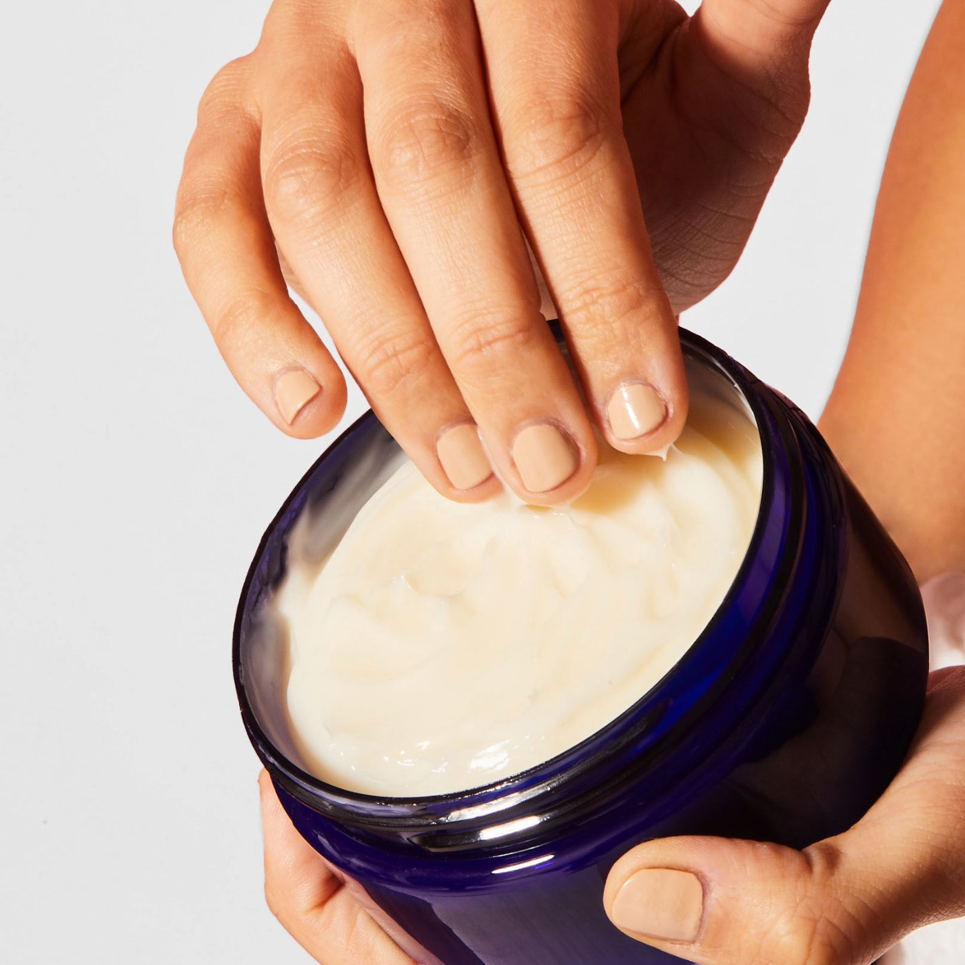 Caswell-Massey Elixir of Love Body Cream. Image shows woman's hand dipping into Body Cream jar