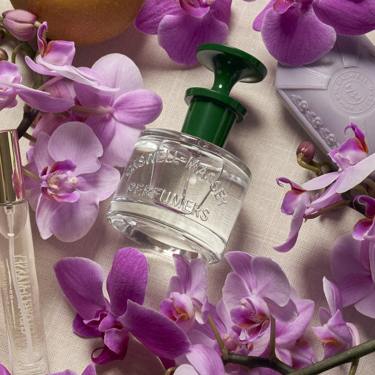 Caswell-Massey Orchid Perfume shown surrounded by fresh orchid blooms