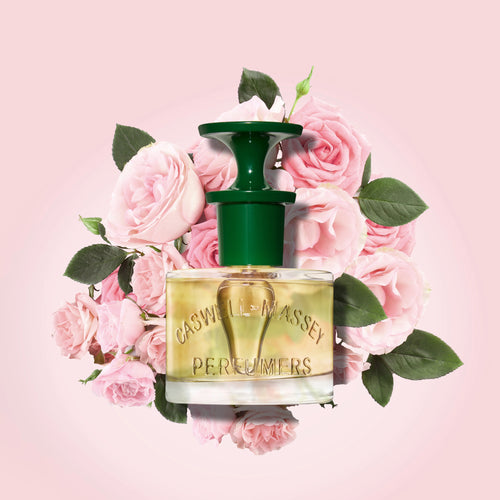 a bottle of perfume surrounded by pink roses