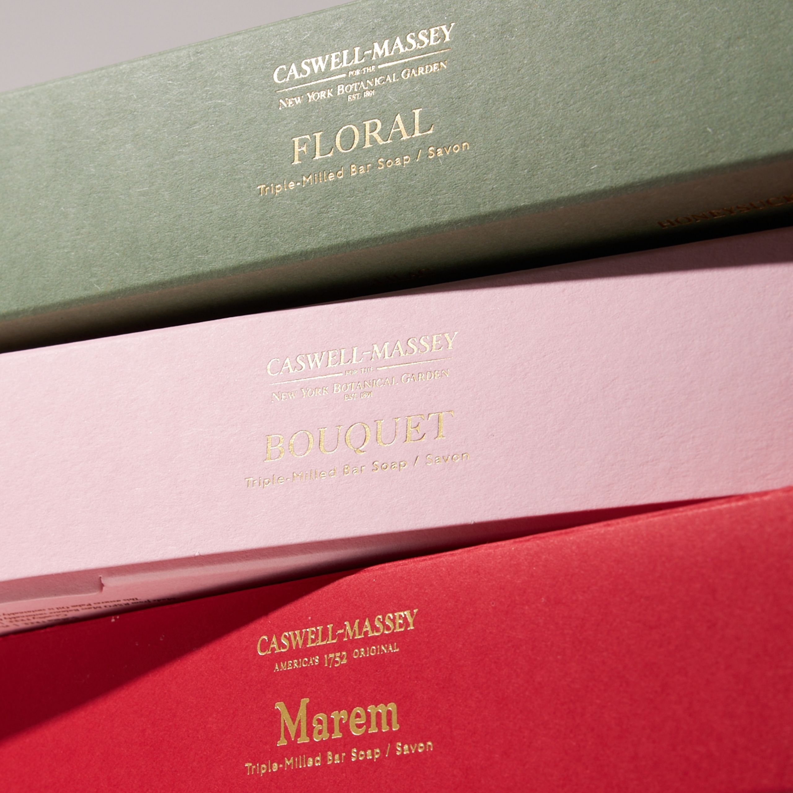 Caswell-Massey Luxury Soap Gift Sets: Three-Soap gift boxes stacked on top of one another, with a green box on top of a pink box on top of a red box