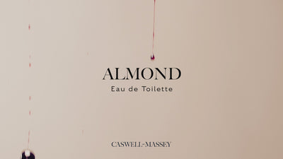 Caswell-Massey Almond Eau de Toilette. Video shows bottle spinning with cherries, almonds, and almond flower petals falling behind and around bottle. 